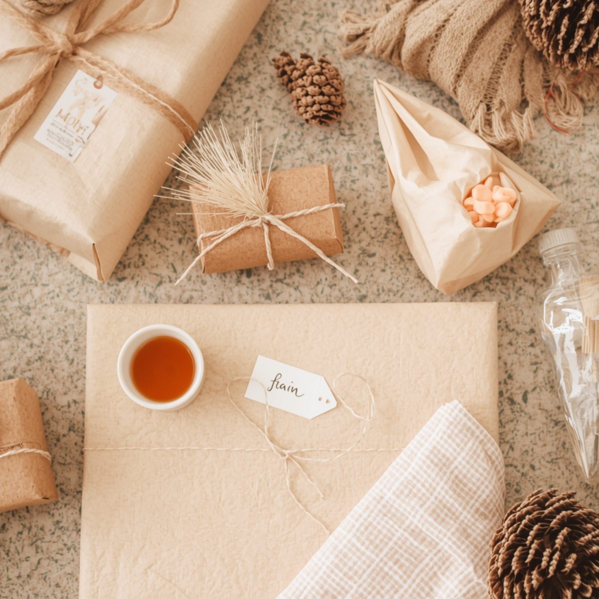 Henkilö viimeistelemässä lahjapakettia käsin